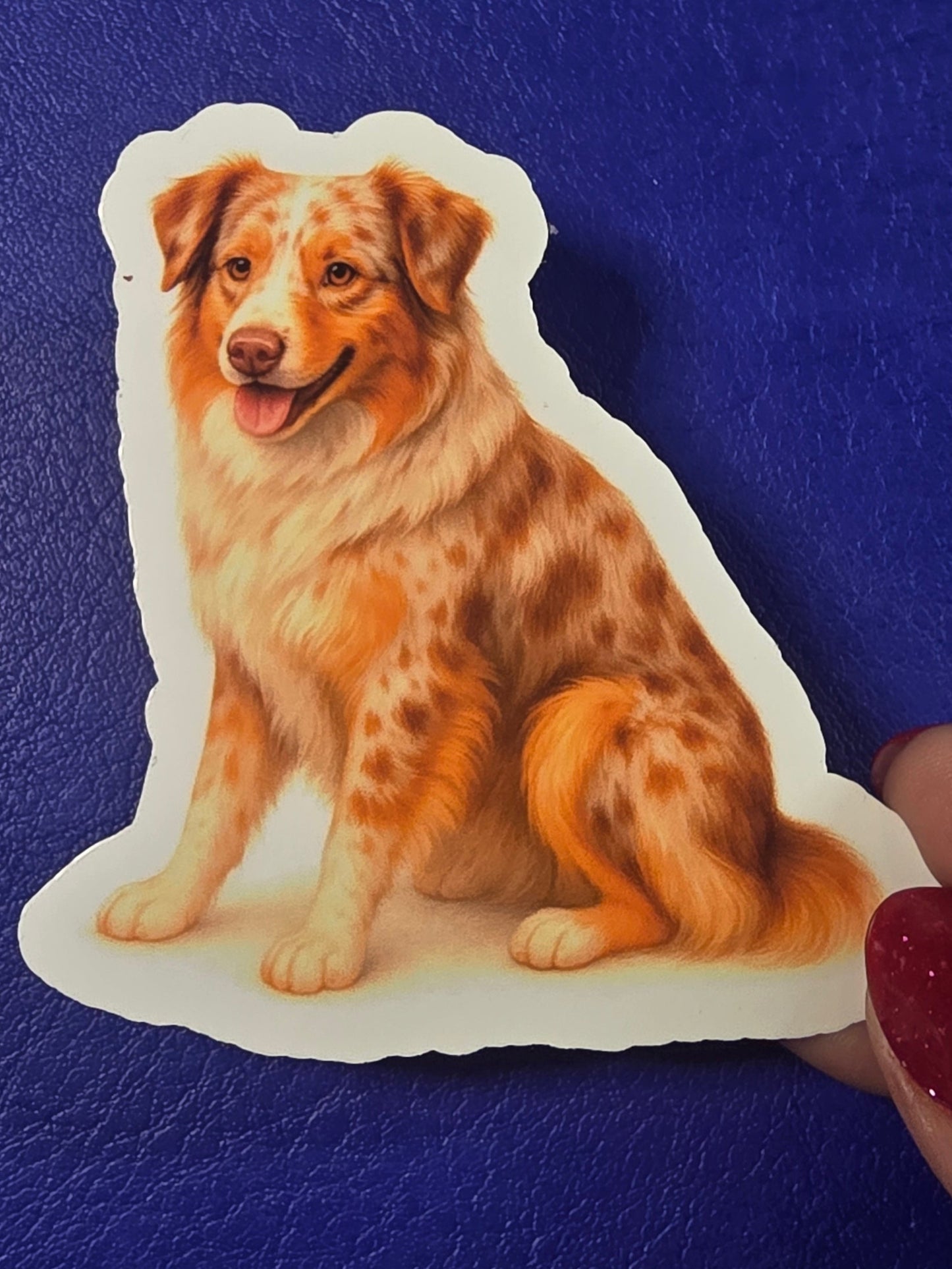 Sticker of a dog held over a blue sketchbook