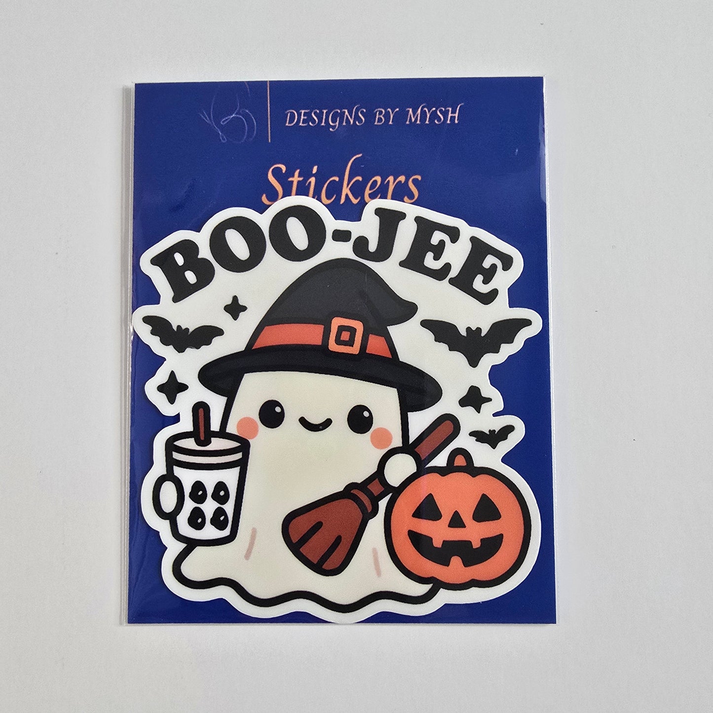 Vinyl sticker of a kawaii ghost wearing a witch hat holding a boba tea, broom, and jack-o'-lantern, surrounded by bats with "BOO-JEE" text.