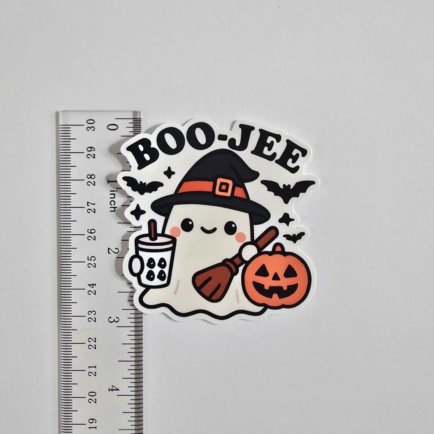 Halloween-themed sticker with 'BOO-JEE' text and a ghost in a witch hat on a gray background with a ruler for scale.