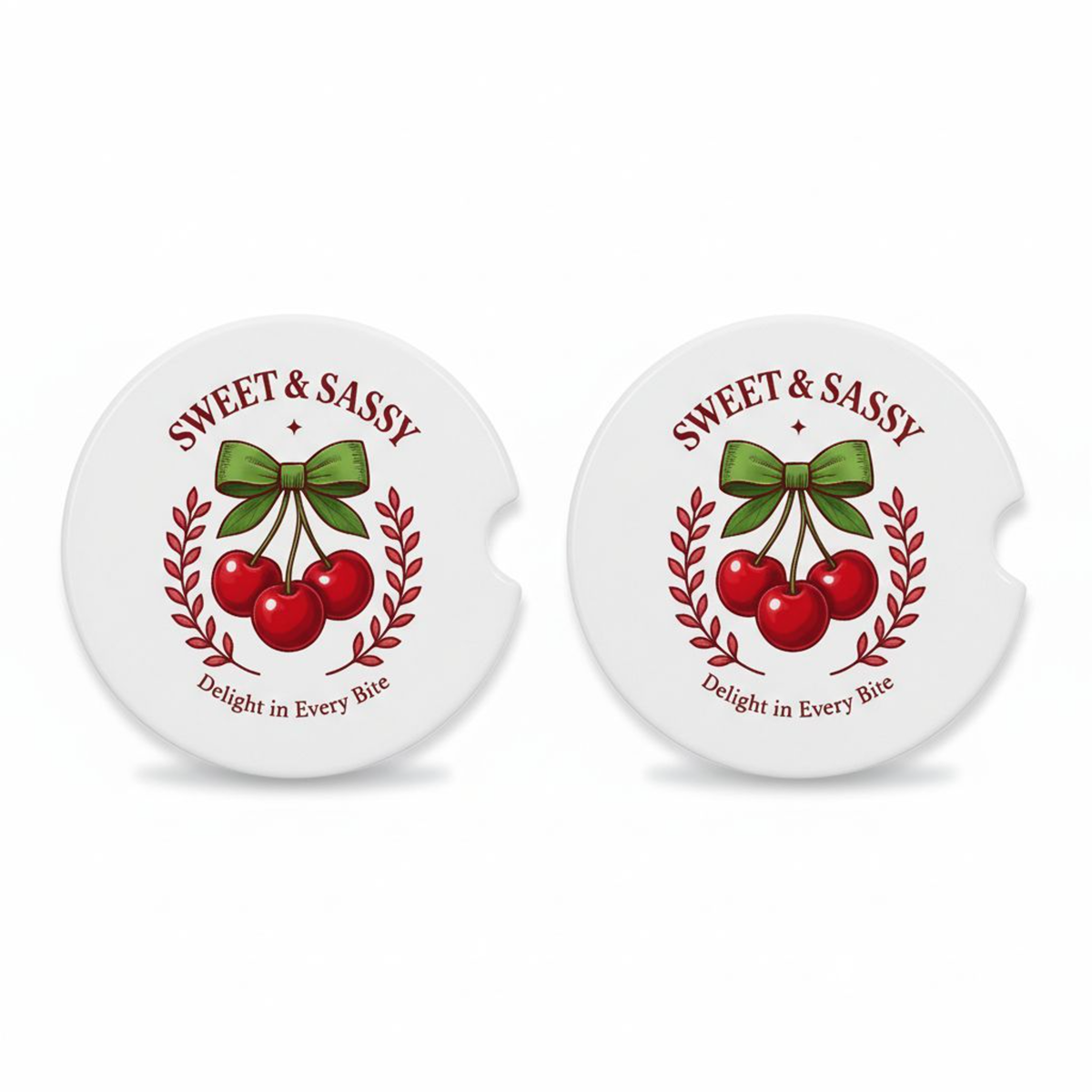 Set of two ceramic car coasters with a retro cherry design, green bow, and the phrases “Sweet & Sassy” and “Delight in Every Bite,” printed on a white background.