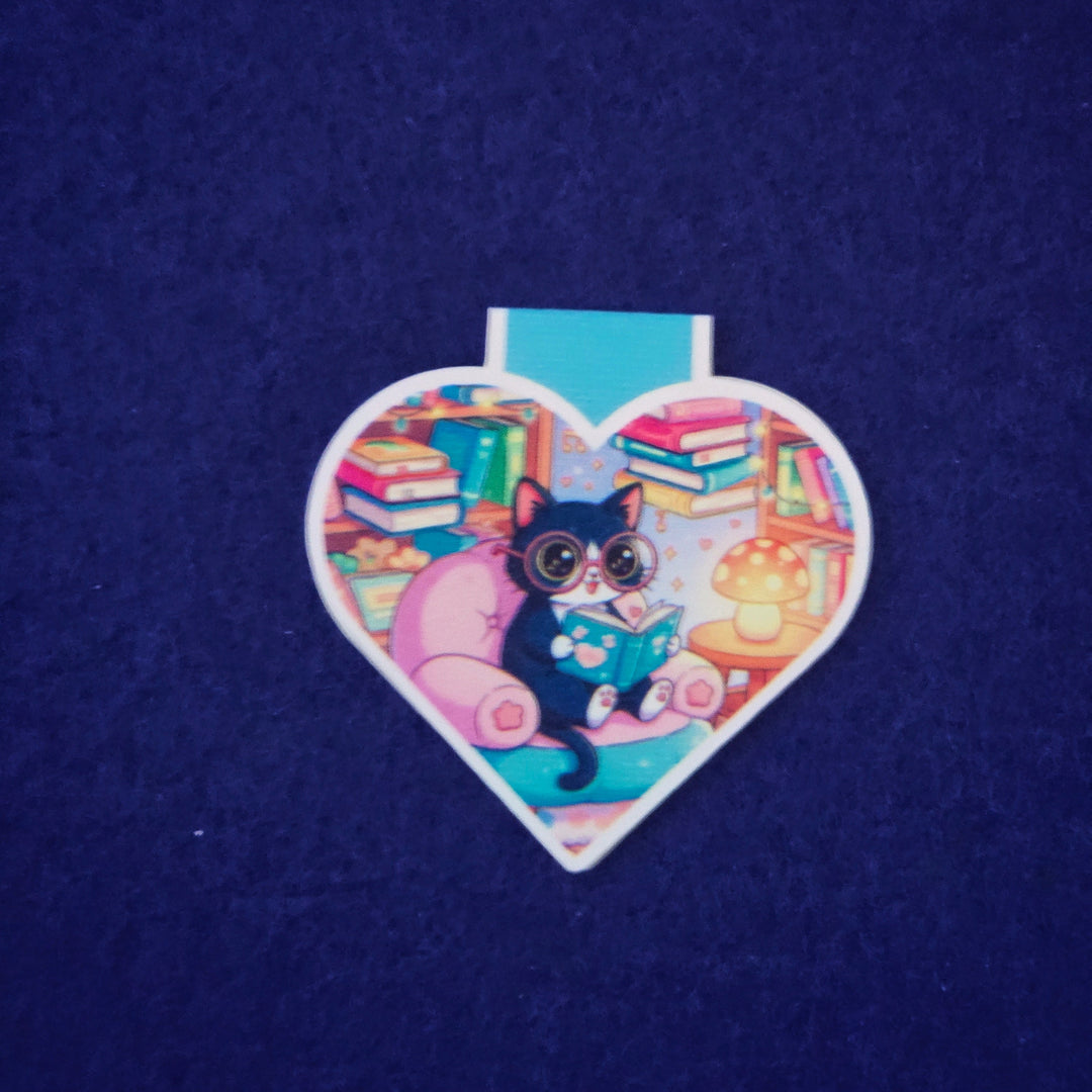Heart-shaped sticker with a cat reading a book design on a dark blue background