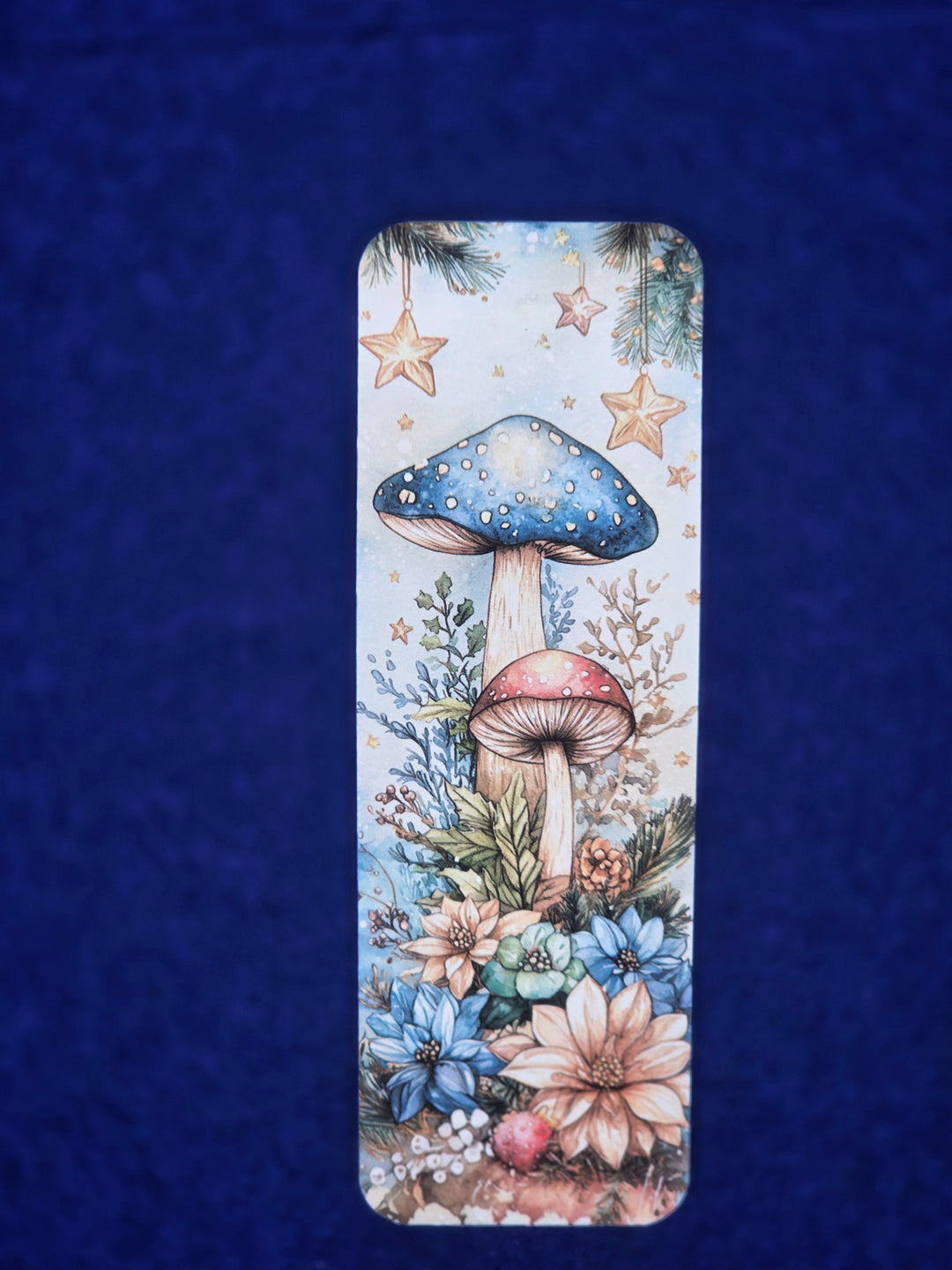 Decorative bookmark with mushrooms and flowers on a blue textured background