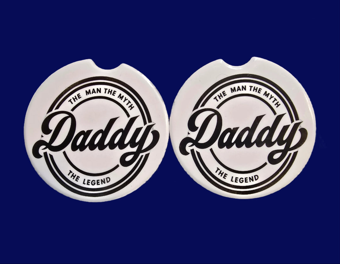 Two circular stickers with a brand logo on a textured surface.