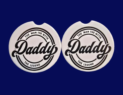 Two circular stickers with a brand logo on a textured surface.