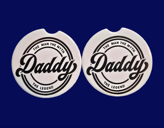 Two circular stickers with a brand logo on a textured surface.