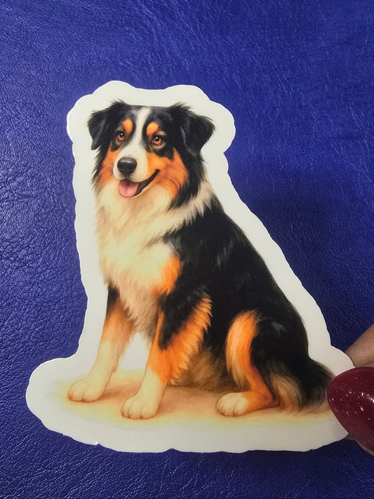 Sticker of a dog on a blue surface with a hand holding it.