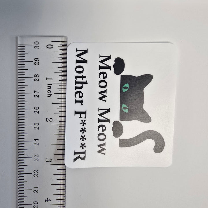 Sticker with a cat graphic and text next to a ruler for size reference on a gray background