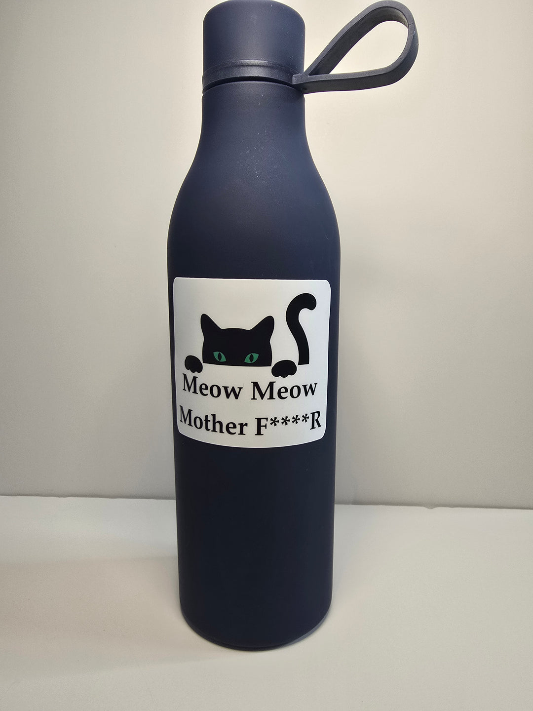 Black water bottle with a humorous label on a white background