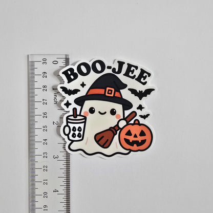 Halloween-themed sticker with 'BOO-JEE' text and a ghost in a witch hat on a gray background with a ruler for scale.