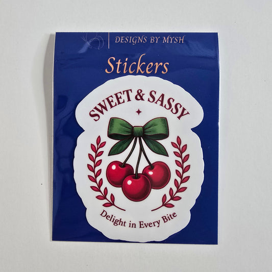 Retro-style cherry sticker with three red cherries tied in a green bow and labeled “Sweet & Sassy” with “Delight in Every Bite.”