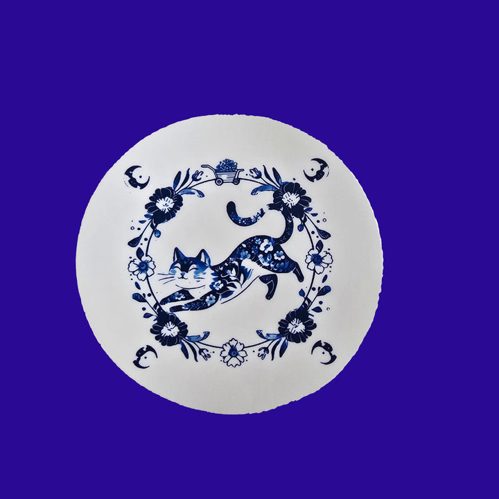 Round white coaster with blue floral and deer design on a light gray background