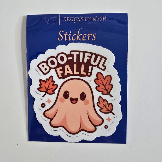 Vinyl die-cut sticker of a cute peach-toned ghost with a smiling face surrounded by falling orange autumn leaves and the phrase “Boo-tiful Fall!”