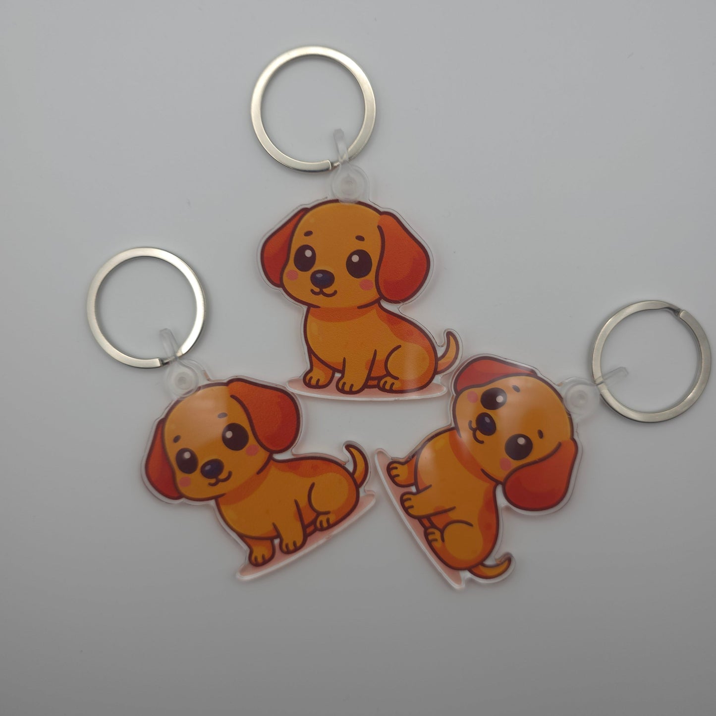 Three cartoon dog keychains on a gray background