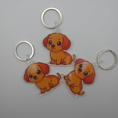 Three cartoon dog keychains on a gray background