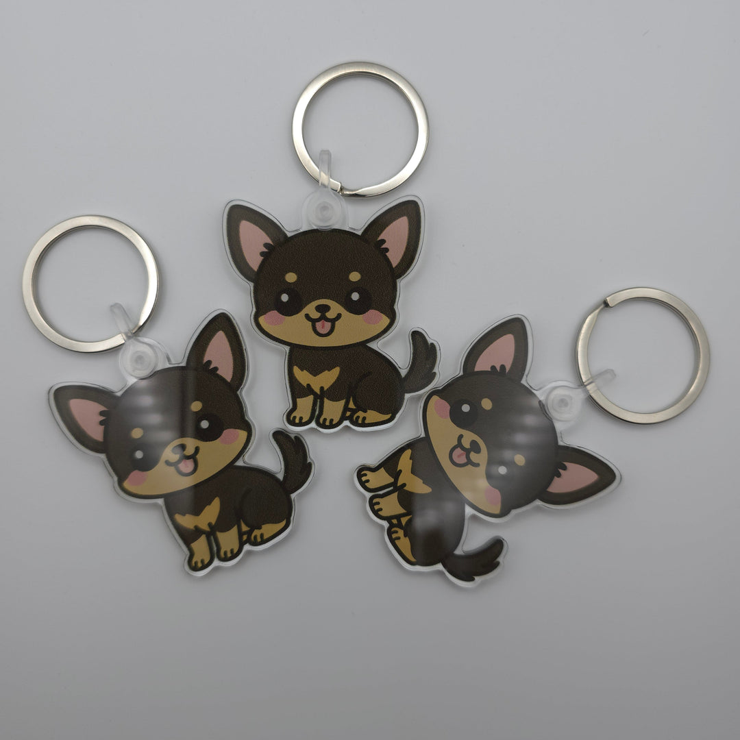 Three dog-shaped keychains on a gray background