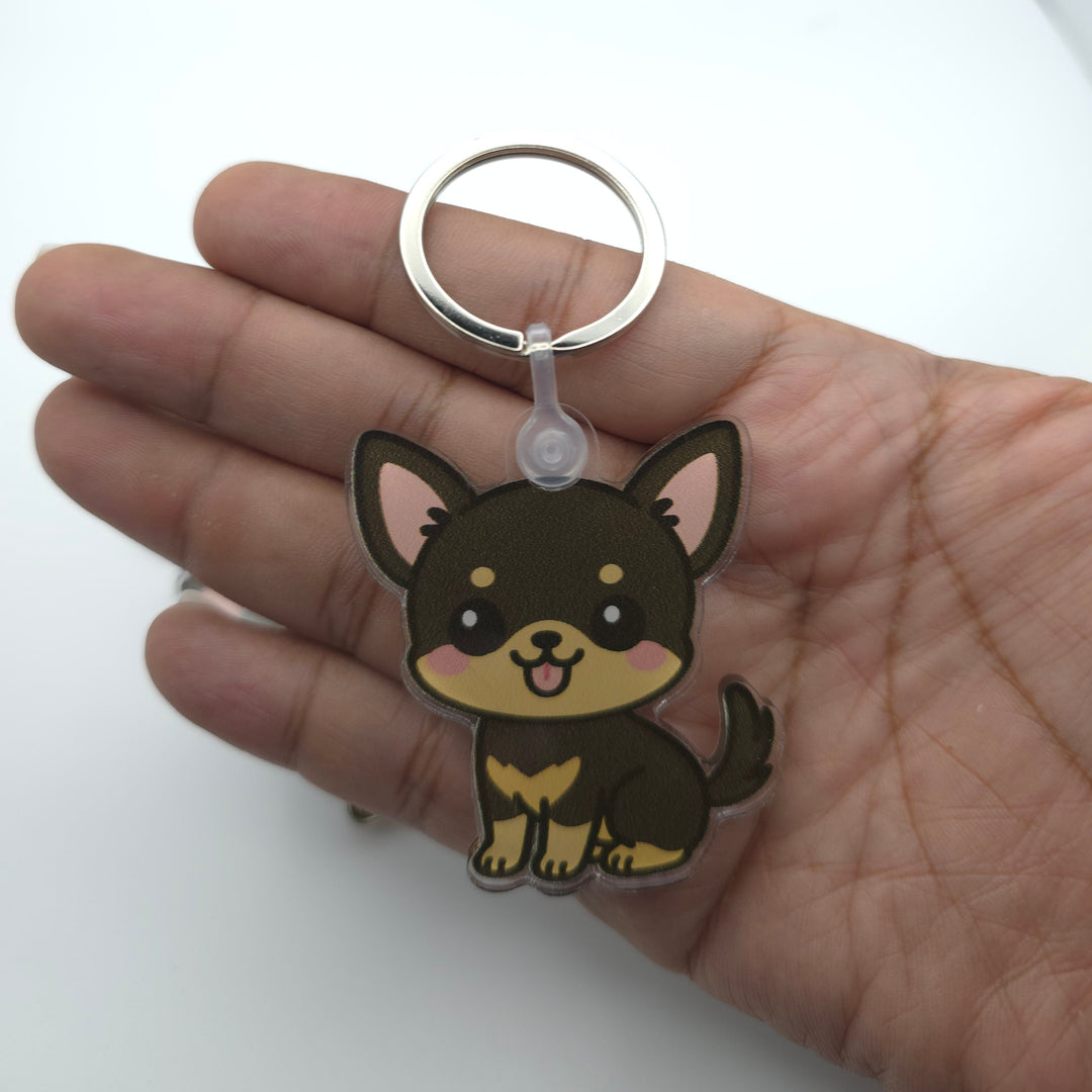 Keychain shaped like a cartoon dog held in a hand on a white background
