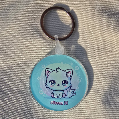 Kawaii Pisces zodiac keychain featuring cute sea creature holding shell on aqua blue background