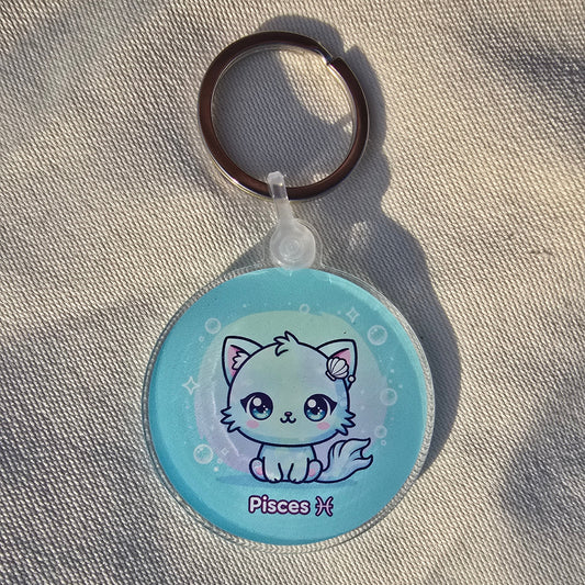 Kawaii Pisces zodiac keychain featuring cute sea creature holding shell on aqua blue background