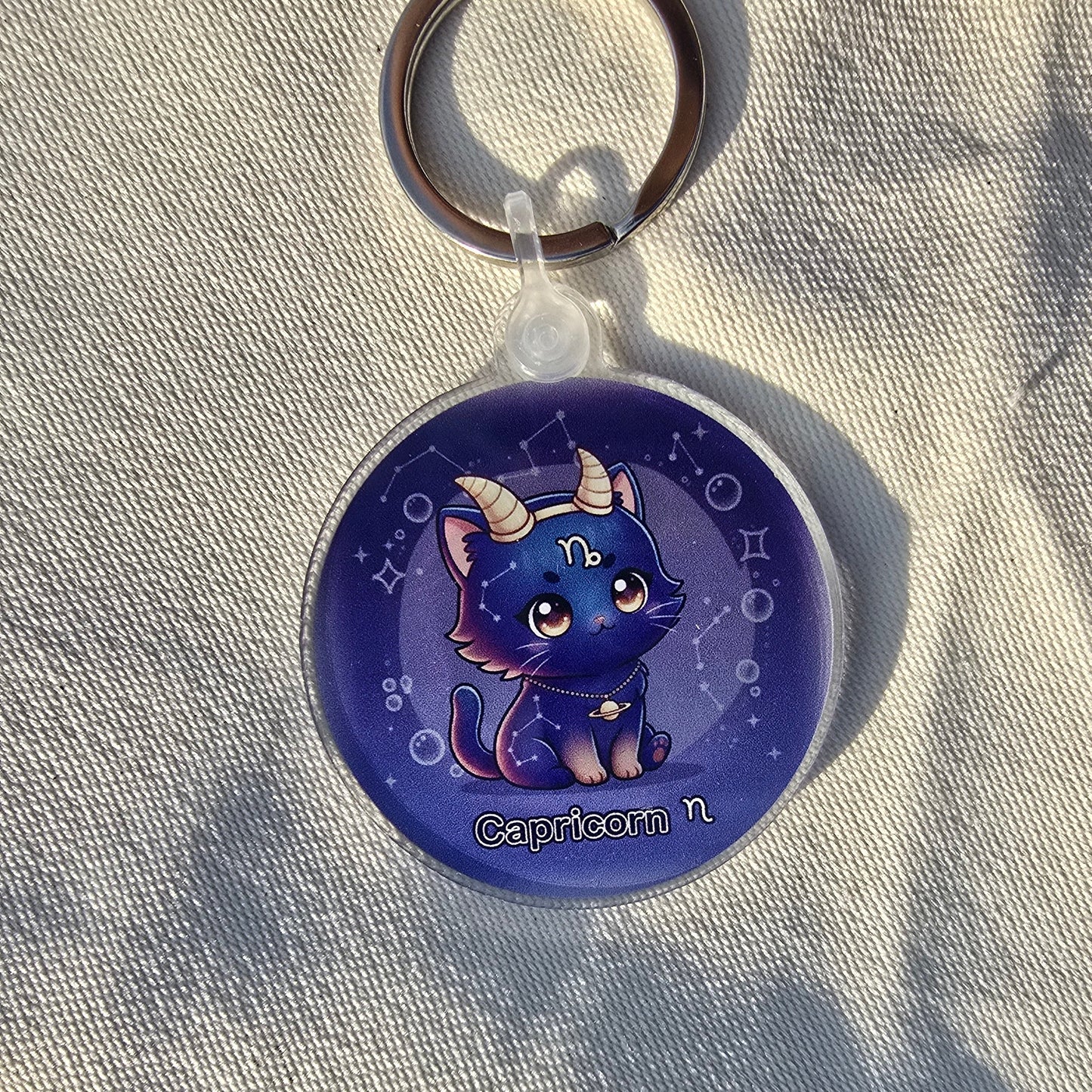 Keychain with a blue creature design on a light fabric background