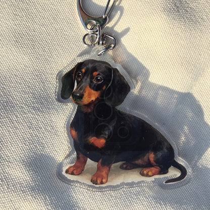 Keychain shaped like a dachshund on a light fabric background