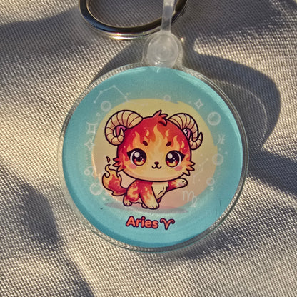 Keychain with Aries zodiac sign design on a textured fabric background