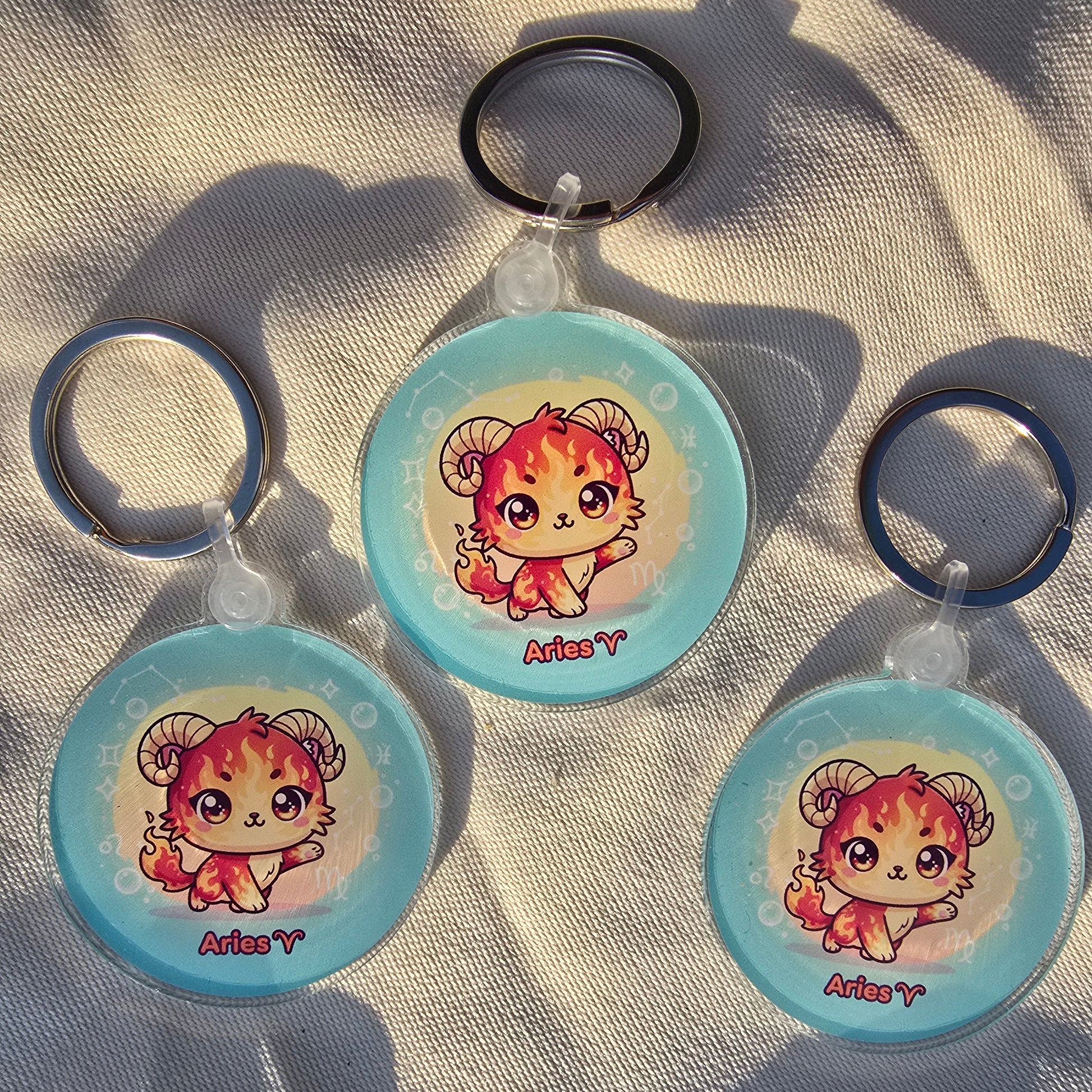 Three round keychains with a cartoon character on a textured surface