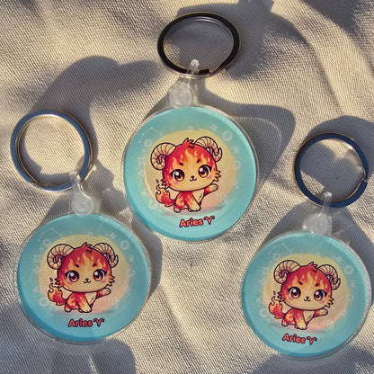 Three round keychains with a cartoon character on a textured surface