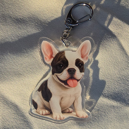 White and black French Bulldog keychain with tongue out and silver lobster clasp on cream fabric