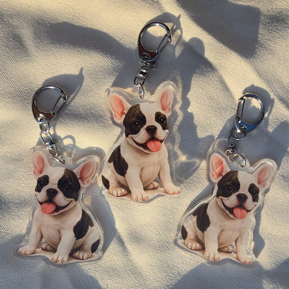 Three white and black French Bulldog acrylic keychains with tongue out and lobster clasps on canvas fabric
