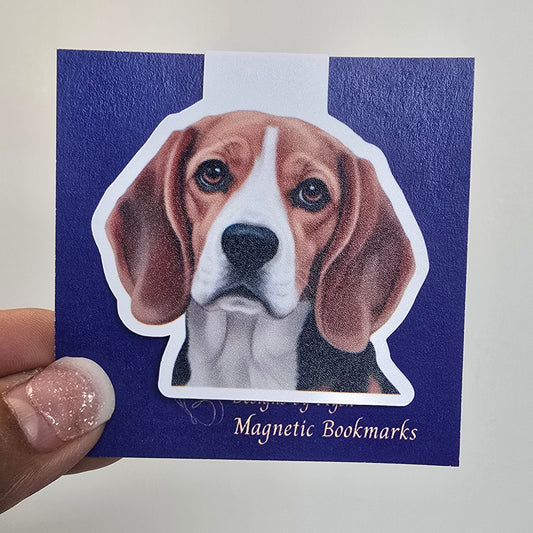 Magnetic bookmark with a dog design held by a hand against a white background