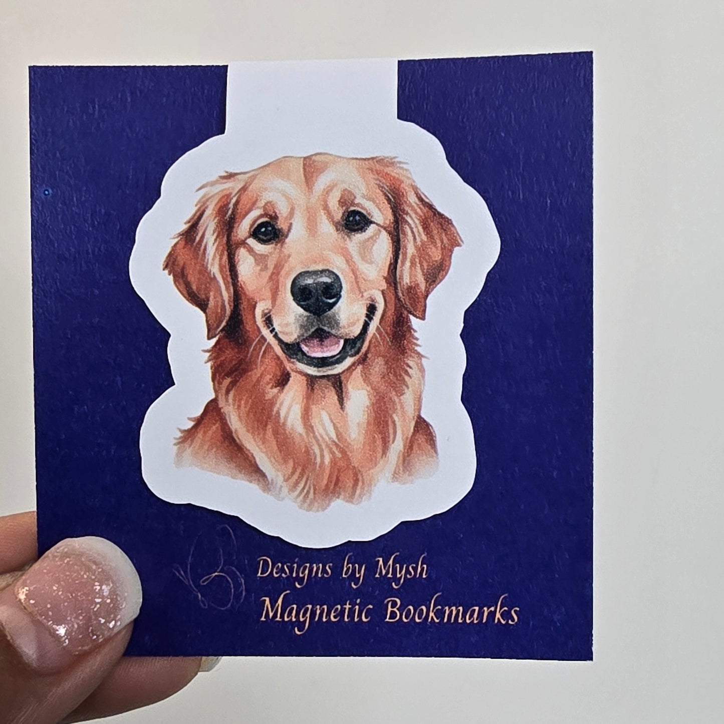 Magnetic bookmark with bear design on a blue card held by a hand.