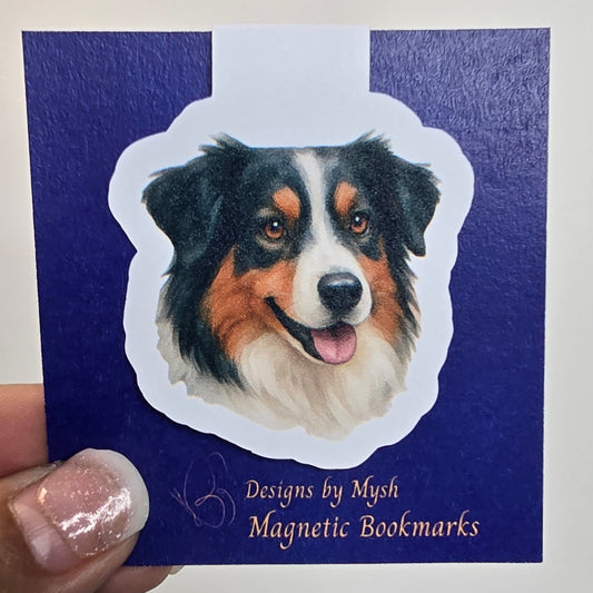 Magnetic bookmark with dog design held by a hand against a white background
