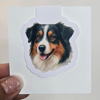 Hand holding a sticker of a dog's face on a white background