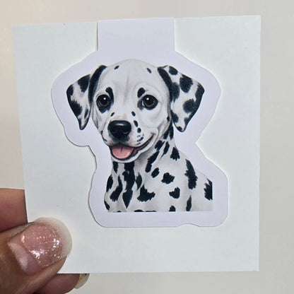 Sticker of a Dalmatian dog held by a hand against a white background