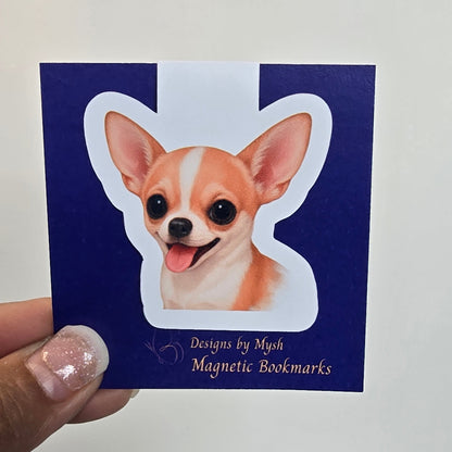 Magnetic bookmark with a dog design held by a hand against a white background