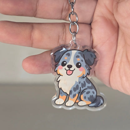 Hand holding a keychain with a cute animal design against a neutral background
