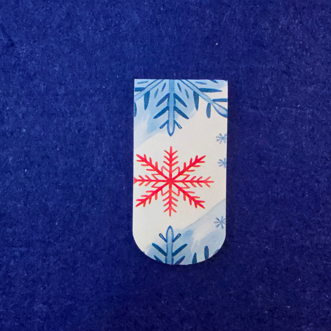 Rectangular tag with red snowflake design on a blue textured background