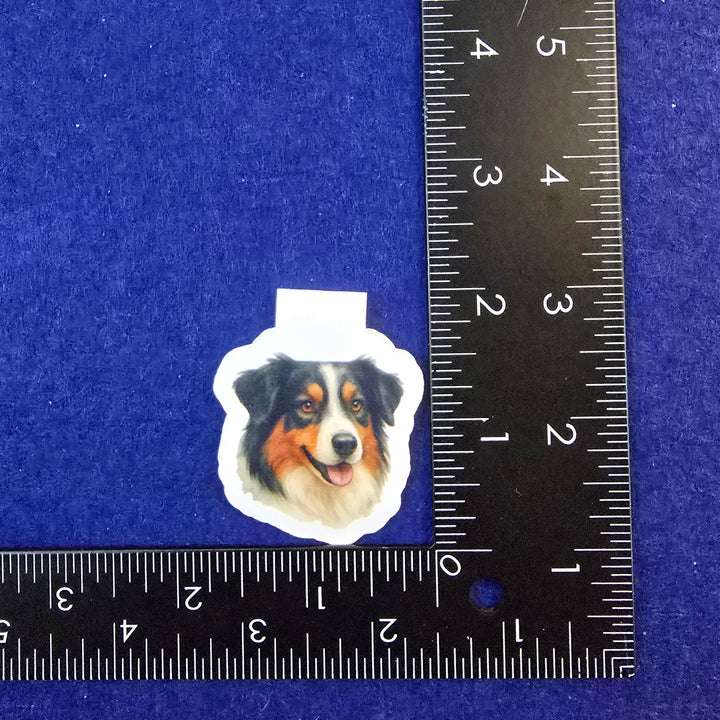 Sticker of a dog's face with a ruler for scale on a blue background