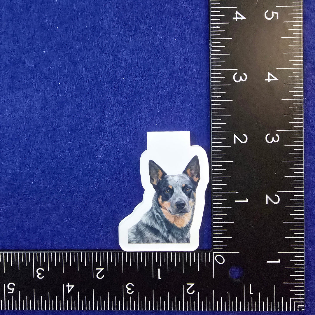 Sticker of a dog on a blue background with a ruler for scale.
