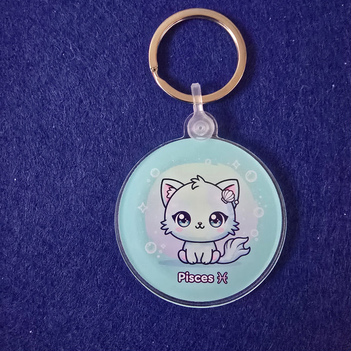 Keychain with a circular design featuring a cat illustration on a blue textured background