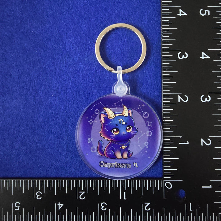 Keychain with a cartoon character on a blue background with a ruler for scale.