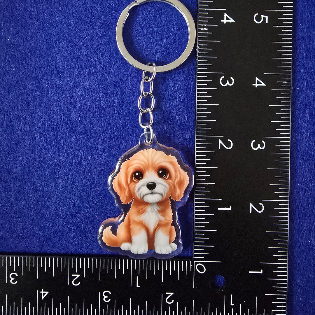 Keychain with a dog design on a blue background with a ruler for scale.