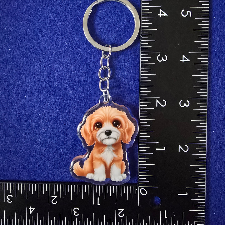 Keychain with a dog design on a blue background with a ruler for scale.