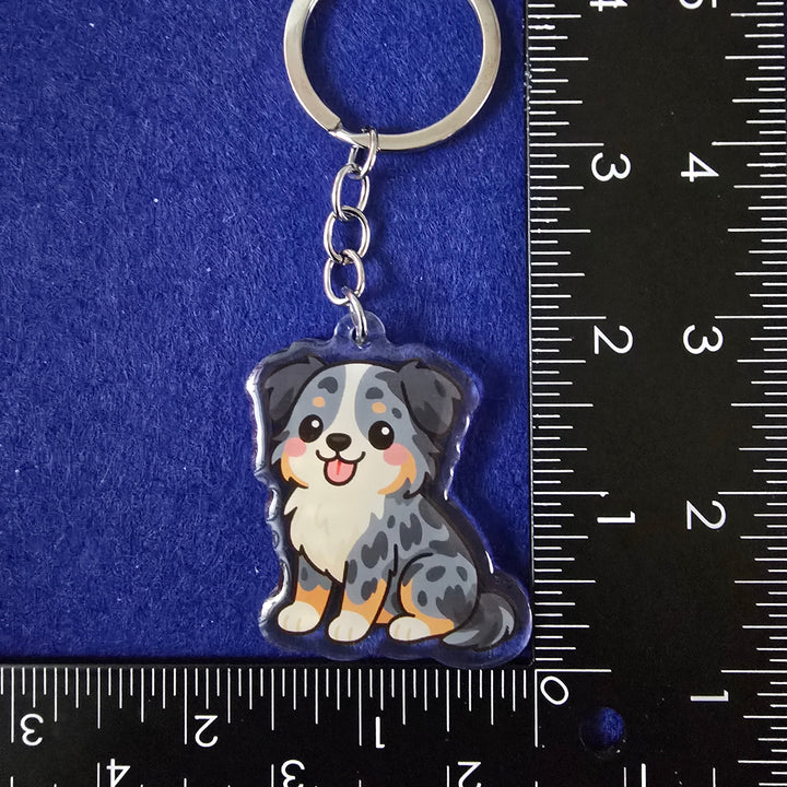 Keychain with a dog design on a blue background with a ruler for scale.