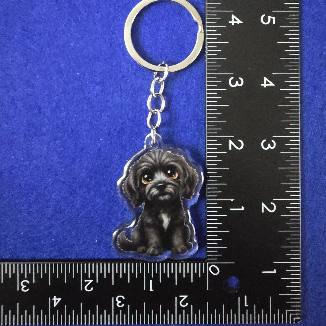 Keychain with a dog design on a blue background with a ruler for scale.