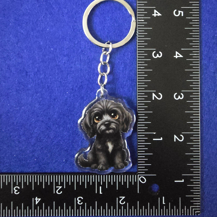Keychain with a dog design on a blue background with a ruler for scale.