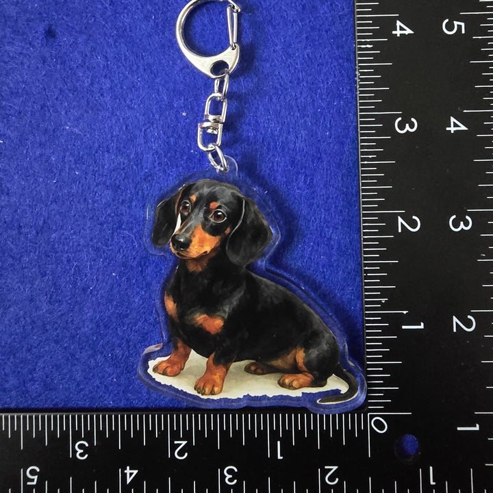 Dog-shaped keychain on a blue surface with a ruler for scale.