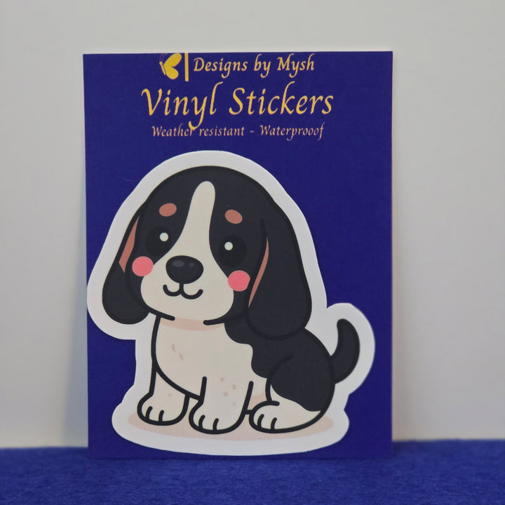 Basset Hound Black white and tan kawaii style sticker on a blue background.