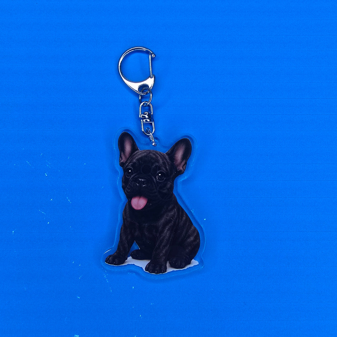 Black dog-shaped keychain on a blue background