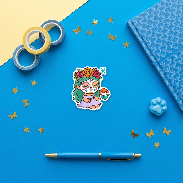 Pisces Sugar Skull Girl 3 inch fridge magnet flat lay with blue stationery